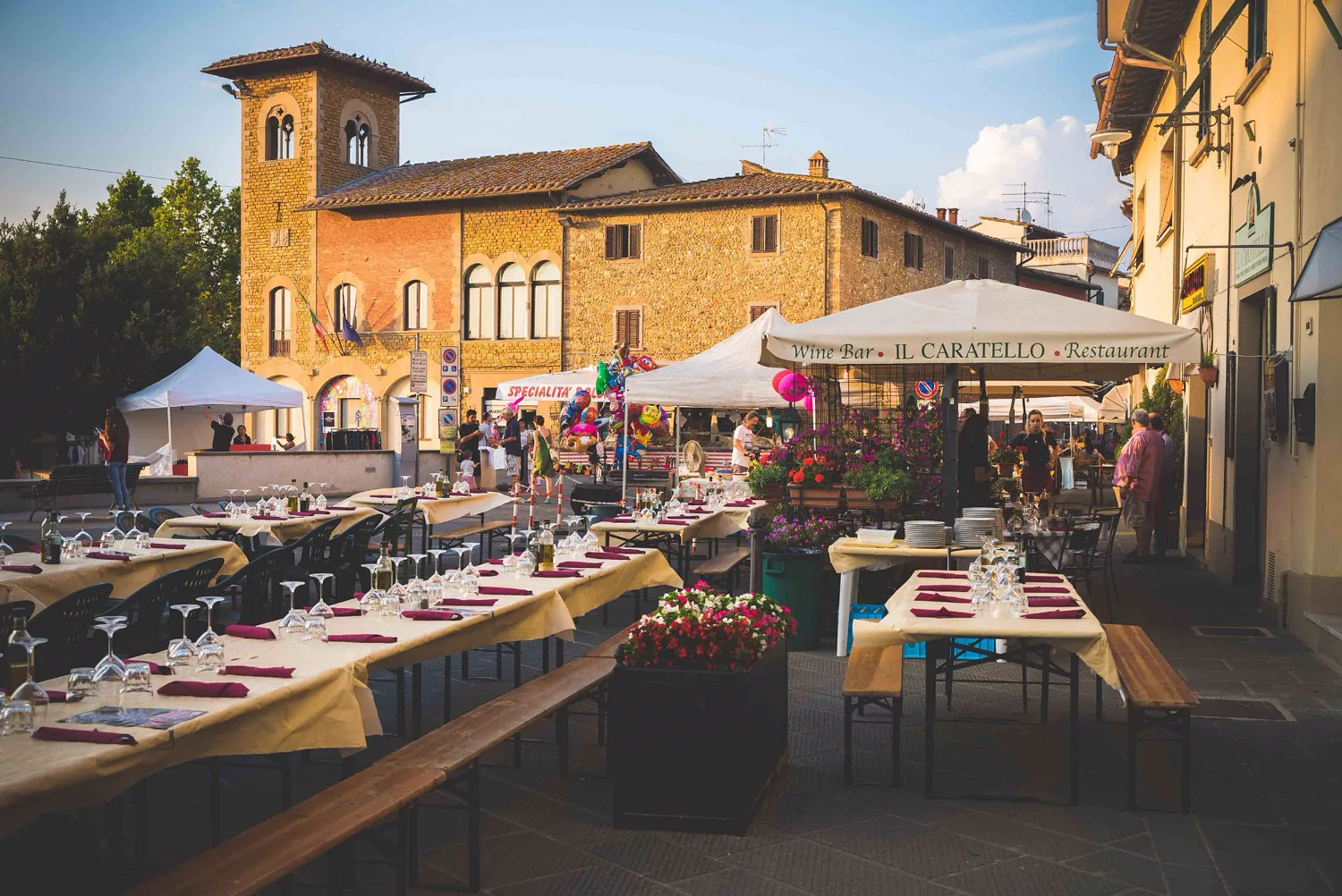 Long tables set for dinner in a Tuscan village square